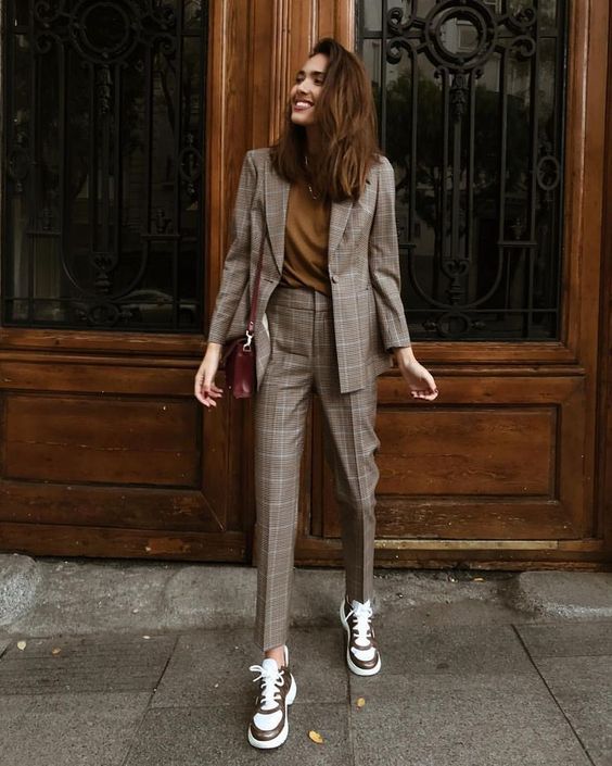 a grey plaid pantsuit, a mustard t-shirt, grey trainers and a burgundy crossbody bag