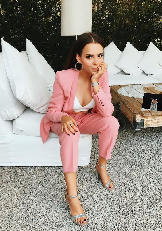 a pink pantsuit, a white top, silver block heels, a watch and statement earrings for a spring office look