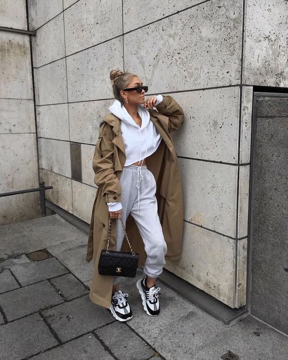 a sporty outfit with a cropped hoodie, joggers, two tone trainers, a camel trench and a black bag