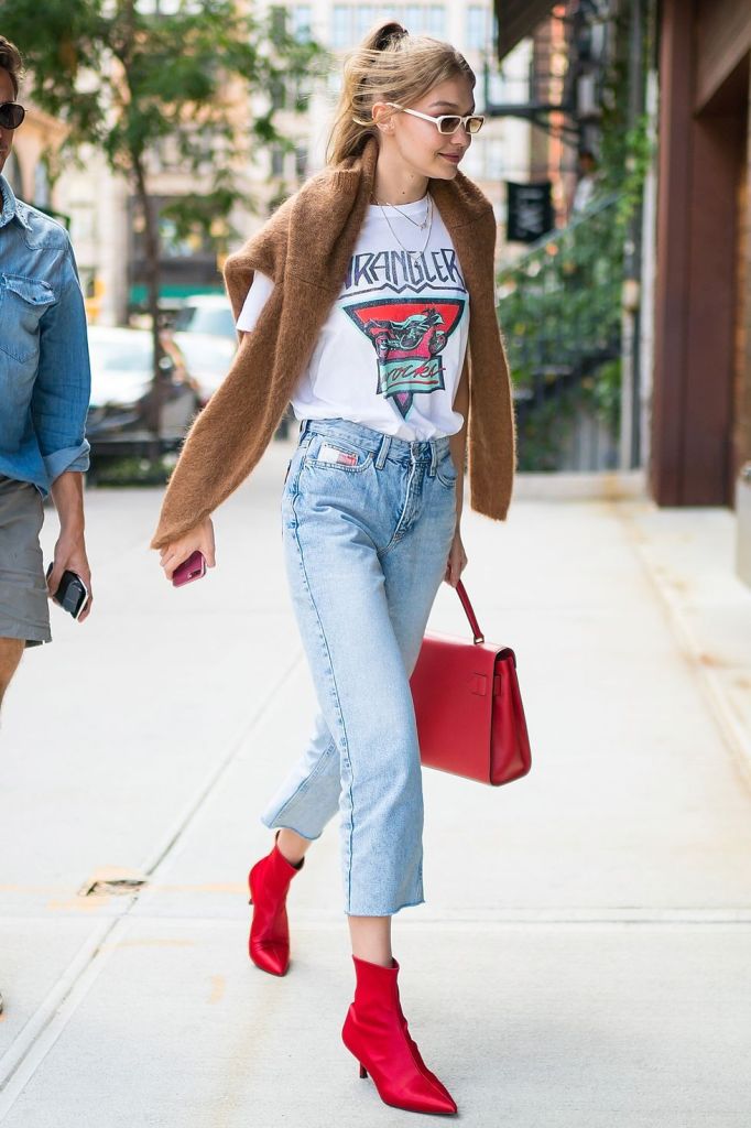 blue straight cropped jeans, red booties and a bag, a printed tee, a camel sweater