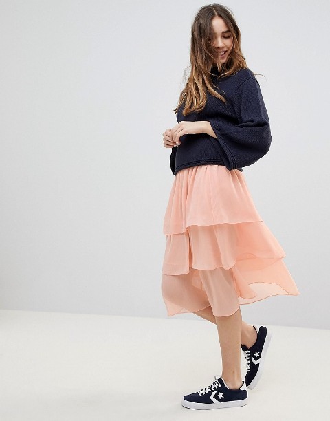 With navy blue loose sweatshirt and black and white sneakers