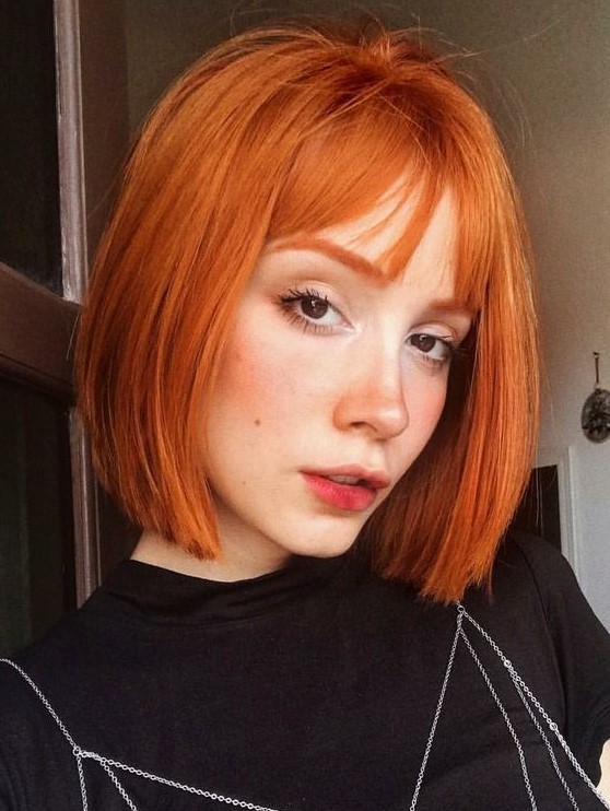 a bold copper red bob with wispy bangs and curved ends is a cool and bright solution, make a statement with this color