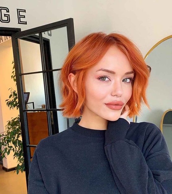A bold copper red chin length bob with a bit of waves is a stylish idea that will catch an eye with color