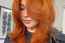 a bold ginger butterfly haircut of medium length, with bottleneck bangs and curled ends is amazing