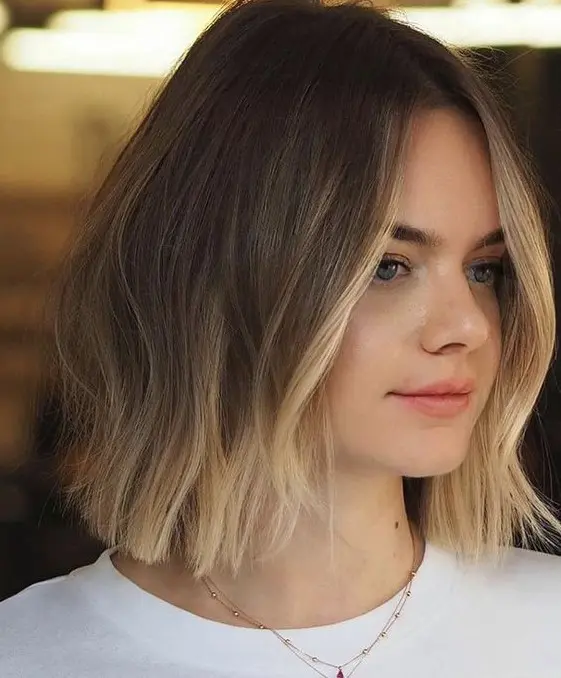 a brunette long bob with a blonde ombre touch and a blonde money piece highlights the face