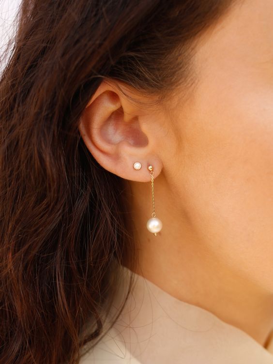 a classic pearl stud plus a catchy pearl chain earring create a modern and fresh look