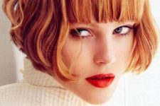 a ginger red ear-length bob with a thick classic fringe and waves is a super bold and eye-catching idea that wows