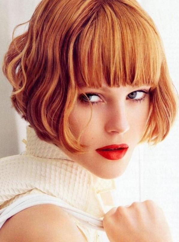 a ginger red ear-length bob with a thick classic fringe and waves is a super bold and eye-catching idea that wows