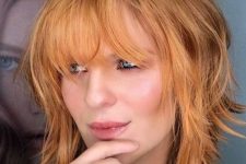 a ginger shaggy medium bob with a darker root and a fringe is a very cool and bold idea to make a statement with color