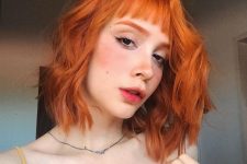 a long wavy ginger bob with a classic fringe is a cool and bright solution that makes a statement with color