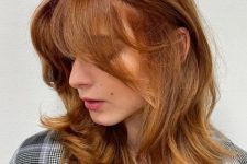 a medium butterfly haircut with some golden blonde highlights done in a super bold ginger color, it looks gorgeous