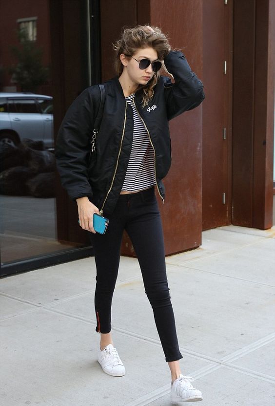a striped t shirt, black leggings, a black bomber jacket and white sneakers for a comfy look