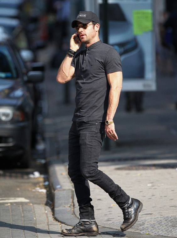 a total black look with a polo shirt, jeans, boots and a baseball cap for a badass look
