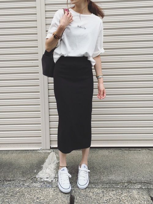 an oversized white t-shirt tucked into a black midi pencil skirt, white sneakers and a black bag