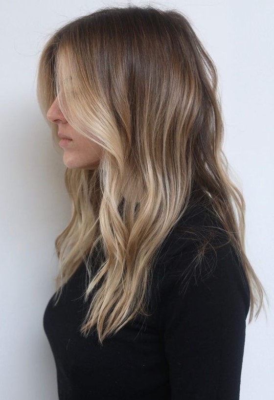 light brunette hair with sunkissed blonde higlights and with waves is a very actual and stylish idea
