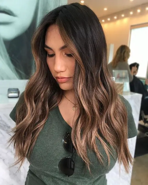 long dark brunette hair with caramel face-framing highlights and balayage looks very bold and chic