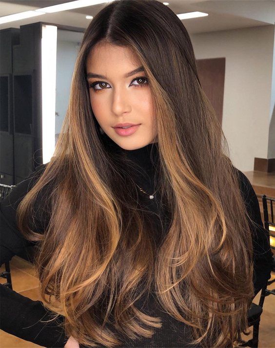 long dark brunette hair with caramel face-framing highlights and volume looks spectacular and chic