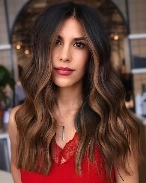 Long dark brunette hair with caramel highlights and face framing ones, with volume and waves is adorable