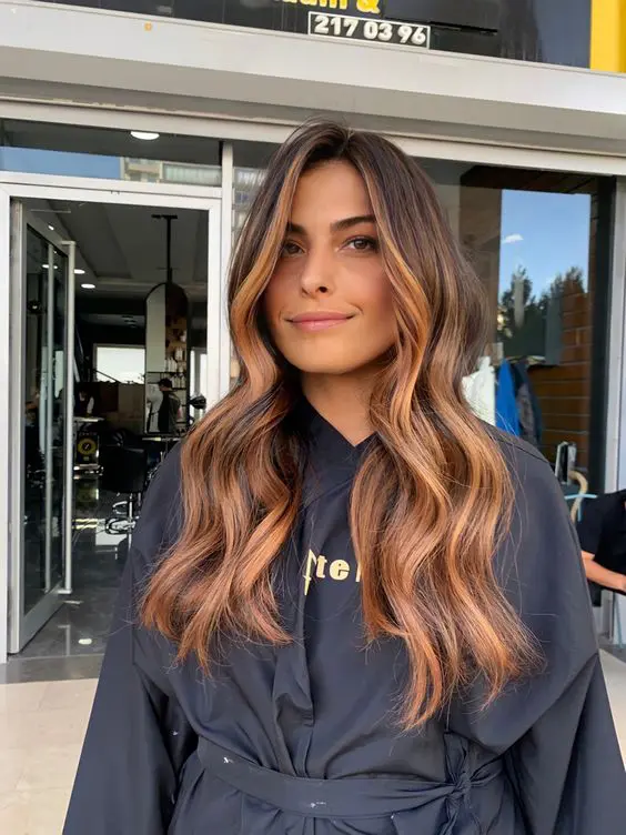 long dark brunette hair with copper balayage and face-framing highlights, volume and waves, is amazing