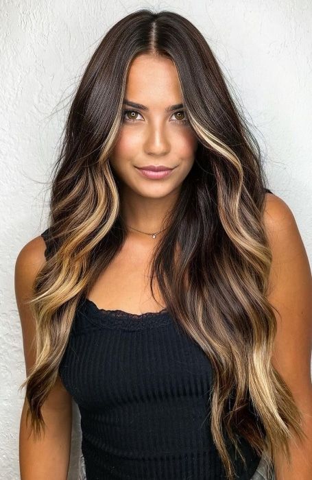 Long dark brunette, lamost black hair with blonde face framing highlights and balayage, volume and waves, is amazing