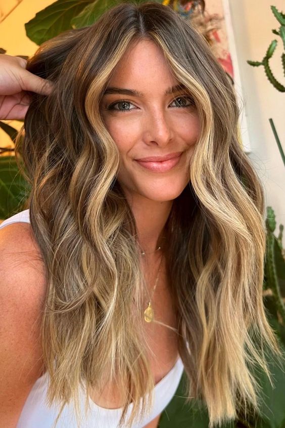 long light brunette hair with blonde face-framing highlights and balayage, with volume and waves, is amazing