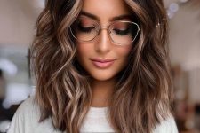 medium-length dark brunette hair with golden blonde highlights and waves, with volume, is a stylish idea