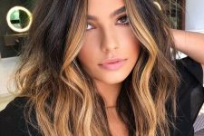 volumetric dark brunette hair with blonde highlights and ombre touches plus messy waves is a super cool idea