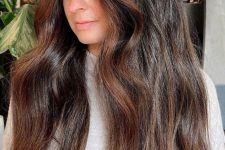 volumetric wavy dark hair with face-framing highlights done in copper looks beautiful, chic and eye-catching