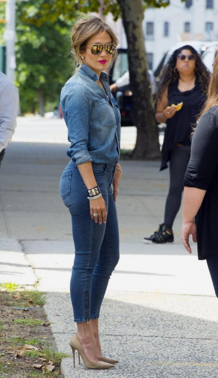 J.Lo wearing a sexy outfit with a chambray shirt, blue skinnies, gold pumps and a red lip looks amazing