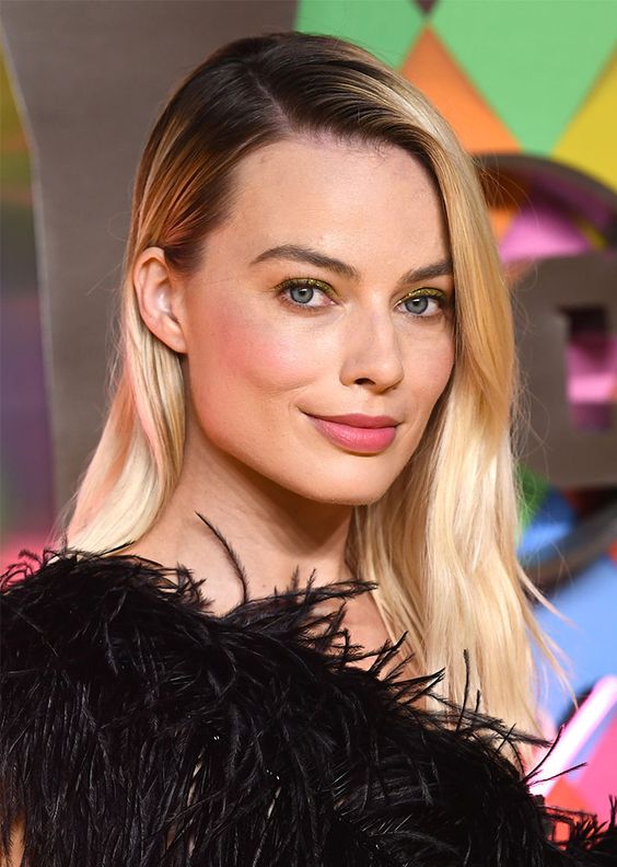 Margot Robbie wearing long rooty blonde hair with a bit of texture looks elegant and chic