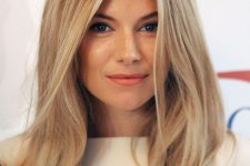 Sienna Miller wearing long blonde hair with a darker root to create a contrasting and bold look