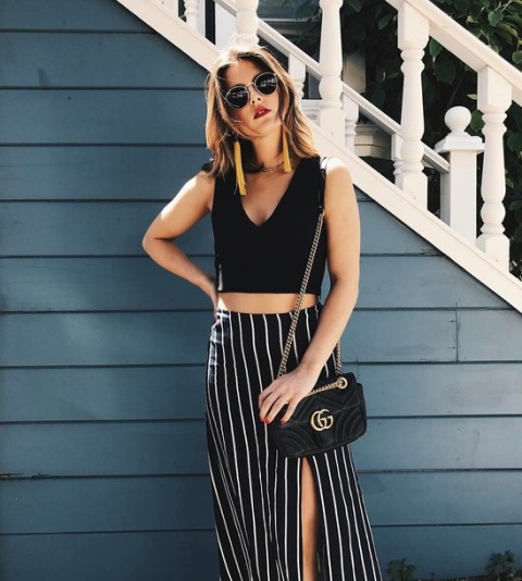 With black crop top and black chain strap bag