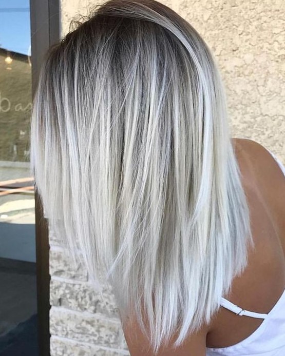a darker root and silver blonde balayage for a chic and bold look with a trendy feel