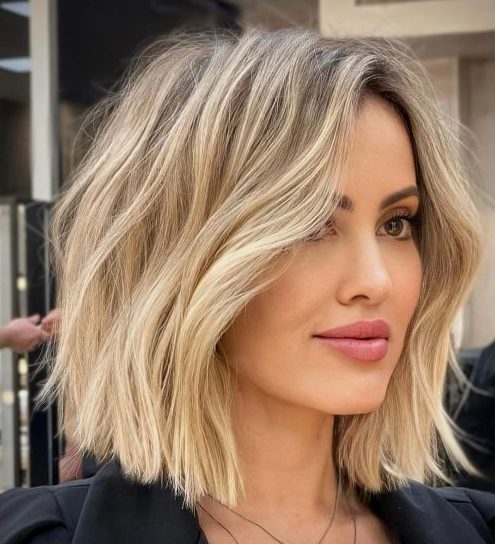 a long blonde bob with a darker root and messy waves is a modern and fresh way to wear blonde