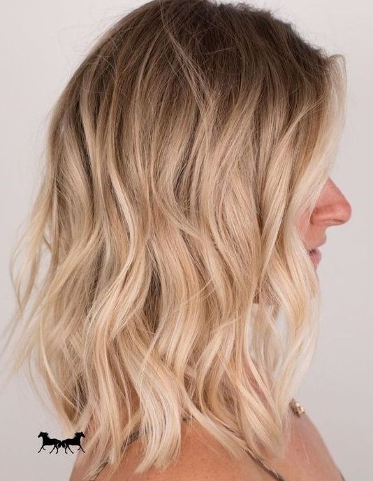 a lovely medium-length hairstyle with a shadow root and shiny blonde waves plus volume is amazing