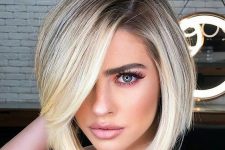 a stylish and chic rooty blonde bob with side bangs and a lot of volume looks very eye-catching and cool