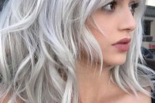 gorgeous medium-length hair with layers and messy waves, done in silver blonde, is a very stylish and eye-catching idea