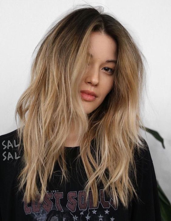 long textured and volumetric blonde hair with a shadow root and layers is a cool and catchy solution
