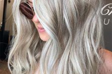 long volumetric hair in silver blonde and blonde, with messy waves, is a stylish and eye-catching solution