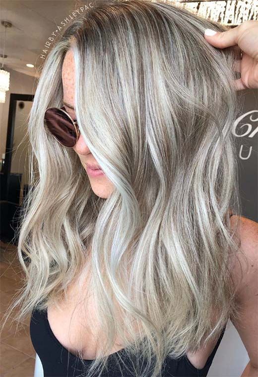 Long volumetric hair in silver blonde and blonde, with messy waves, is a stylish and eye catching solution
