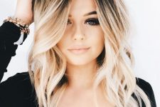 medium bleached blonde hair with a darker root and some waves is a cool and catchy idea with plenty of contrast
