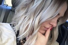medium-length hair with darker root, silver blonde balayage and messy waves is a chic and cool idea