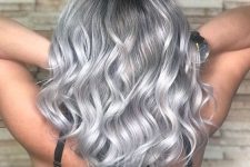 medium-length silver blonde hair with a darker root, waves down, is a chic and eye-catching idea to rock