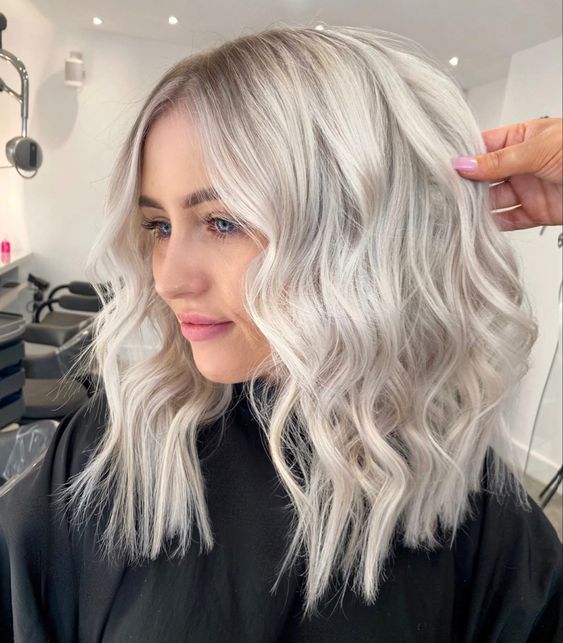 medium-length silver blonde hair with a lot of volume and waves is a stylish and catchy idea that looks wow