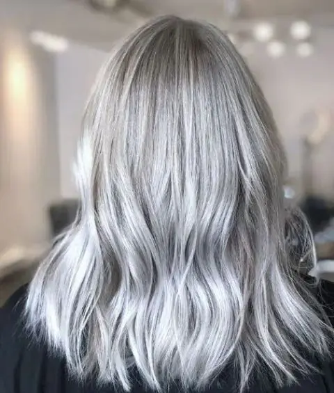 Medium length silver blonde hair with messy texture and a bit of volume is a catchy and cool solution