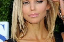 pretty medium-length warm blonde hair with a shadow root and layers is a cool and chic idea that flatters the face