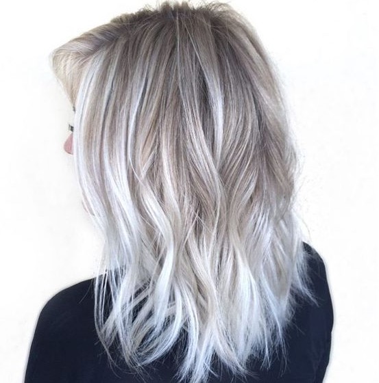 silver blonde balayage with a darker root and lighter ends, with volume and waves is a cool idea