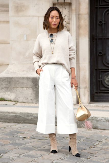 With gray loose sweater, golden bag and beige and black suede boots