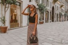 a black ruffle strap crop top, a pink polka dot midi skirt, strappy heels and a black bag for summer