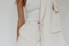 a creamy short suit with high waisted shorts and an oversized blazer and a white halter neckline top